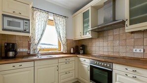 Una cocina equipada con microondas, horno y cafetera.