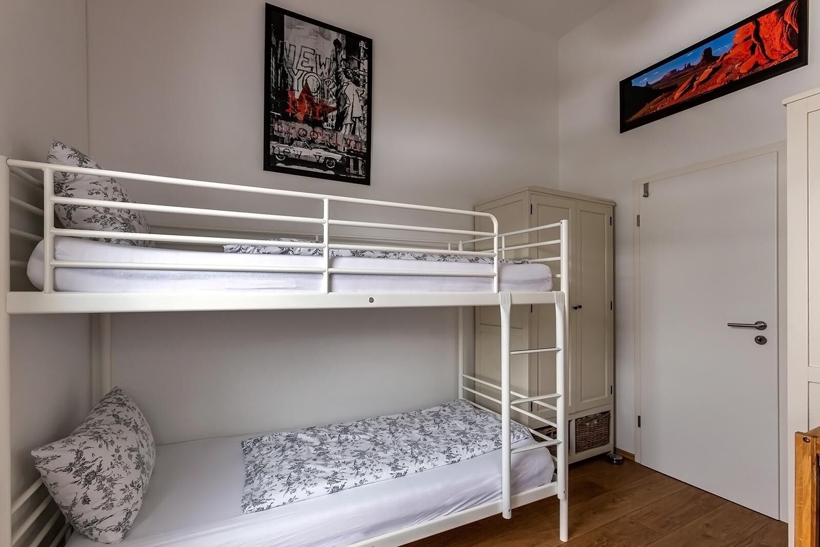 Ein Schlafzimmer mit Etagenbetten, einer Tür und einem Poster an der Wand.