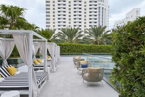 A rooftop lounge with outdoor seating, a glass balustrade, and a view of high-rise buildings. - 2 Connecting Suites at a 4⭐️ Hotel (Miami Beach)