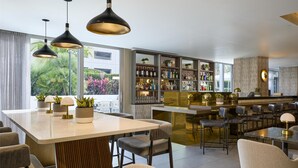 Un espace bar moderne doté d’un long comptoir, de tabourets et d’une variété de bouteilles et de verres.