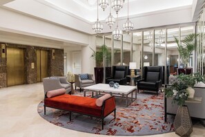 A spacious lobby with a red bench, multiple seating options, a coffee table, and a large mirror reflecting the space. - 2 Connecting Suites at a 5⭐️ Hotel (San Francisco)