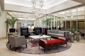 Eine geräumige Lobby mit hoher Decke, modernen Möbeln und großen Fenstern, die für viel Tageslicht sorgen.
