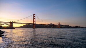 A bridge over water with a sunset in the background.