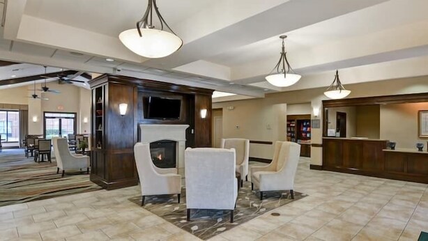 A spacious lobby with a fireplace, comfortable seating, and a reception desk. - 2 Connecting Suites at a  Hotel (Houston)