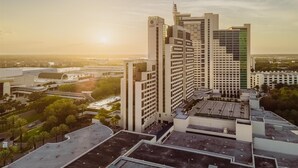 A high-rise building with a modern architectural design, featuring a prominent vertical element and a flat roof. - 2 Connecting Suites at a 4.5⭐️ Hotel (Orlando)