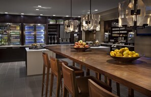 A modern kitchen with a central island, bar stools, and a variety of kitchen appliances. - 2 Connecting Suites at a 4⭐️ Hotel (New York)