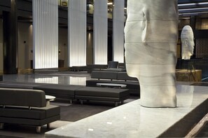 A modern lobby with a large white sculpture, seating areas, and a reflective floor. - 2 Connecting Suites at a 4⭐️ Hotel (New York)