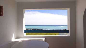 A bathroom with a view of the ocean through a window.