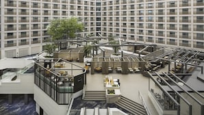 A modern hotel atrium with a central open space, multiple floors, and a glass ceiling. - 2 Connecting Suites at a 4⭐️ Hotel (Burlingame)