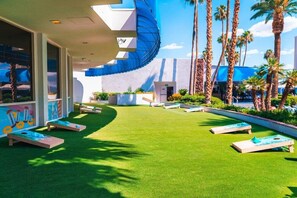 Relax in a serene outdoor space surrounded by lush greenery and comfortable loungers.