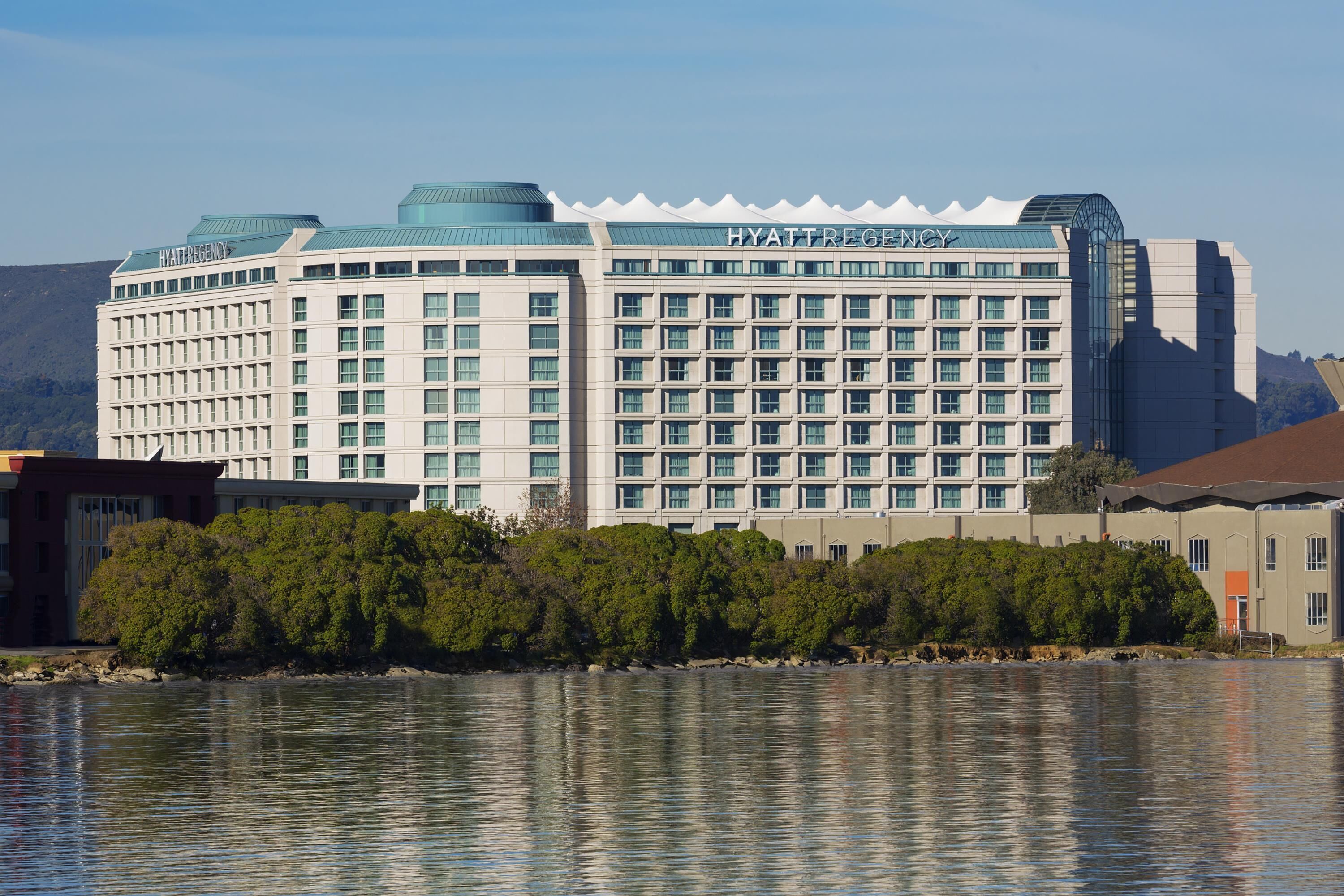 Ein großes, mehrgeschossiges Hotel mit modernem Design, mit einem gut sichtbaren Schriftzug "HYATT REGENCY".