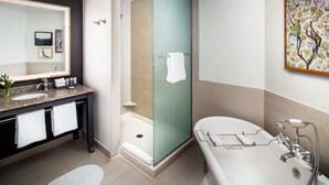 A modern bathroom with a granite countertop sink, a glass-enclosed shower, and a freestanding bathtub. - 2 Connecting Suites at a 4⭐️ Hotel (Savannah)