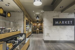 Een modern interieur met een marmeren wand, een glazen vitrine met snacks, en een 'MARKET' bord.