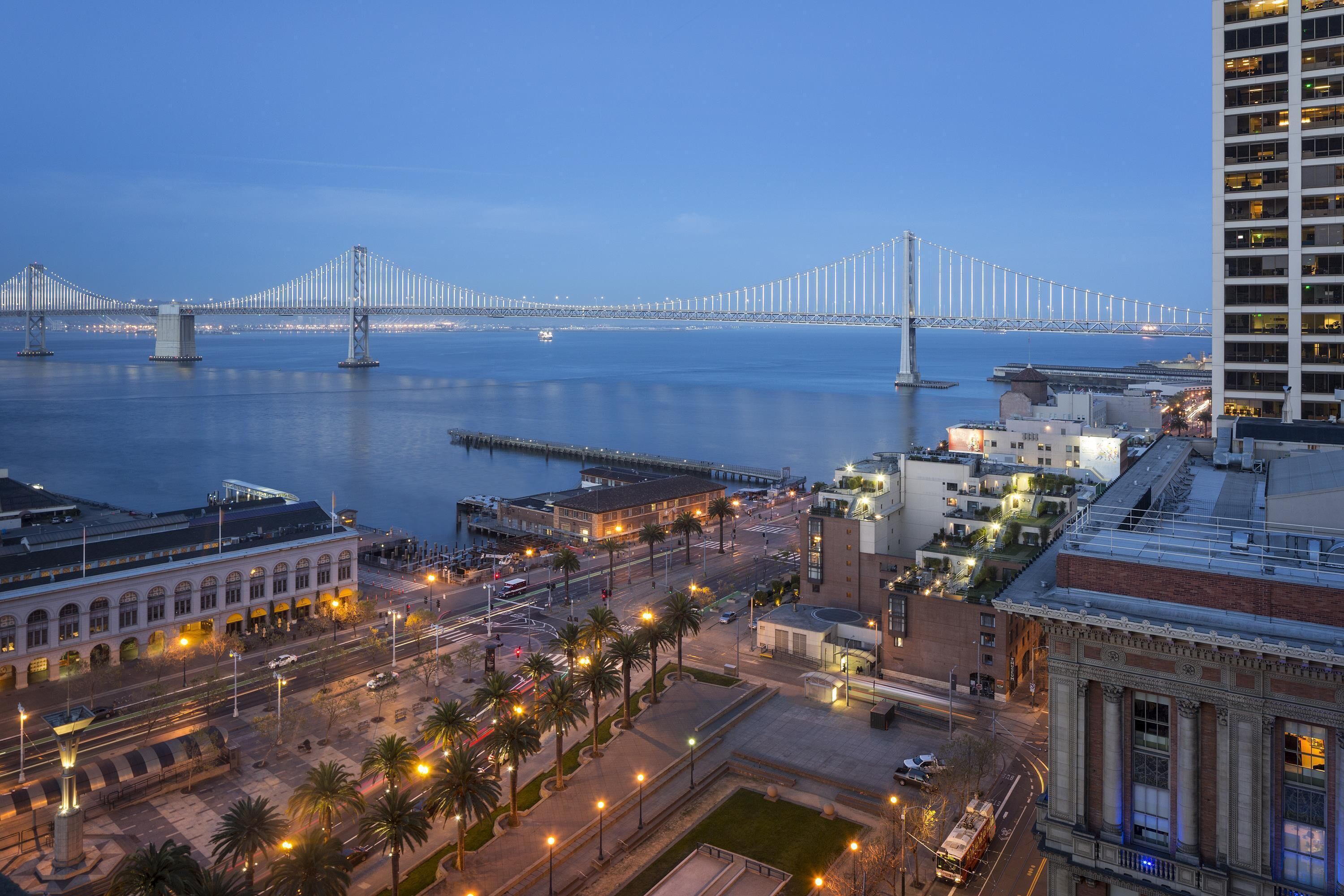 A cityscape with a prominent bridge, a waterfront, and buildings with visible architectural details.