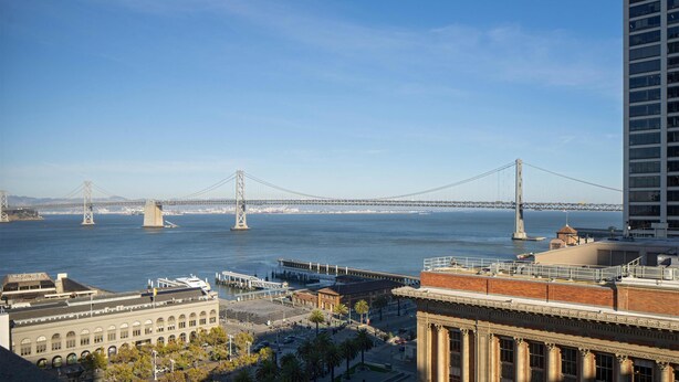 A cityscape with a prominent bridge, buildings, and a waterfront. - Suite + Connecting Room at a 4⭐️ Hotel (San Francisco)