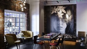 A modern interior with a large window, a dining area with a table and chairs, and a mural on the wall.