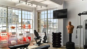 A gym with exercise equipment, a large window, and a city view.