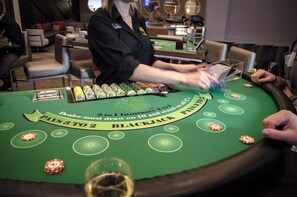 Une table de blackjack avec des jetons et un croupier.