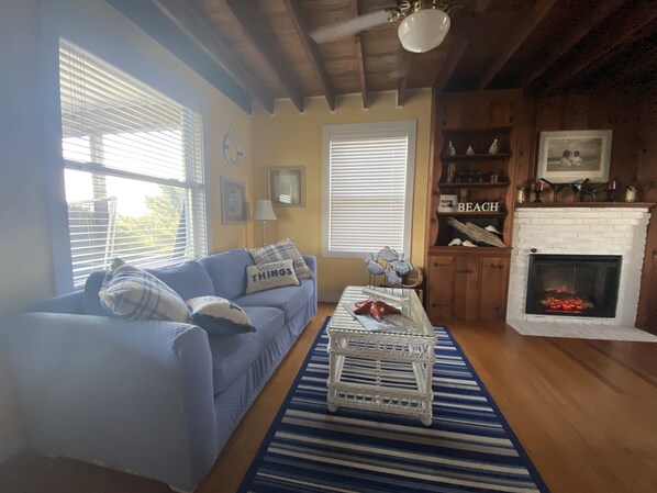 Ein gemütliches Wohnzimmer mit einem blauen Sofa, einem weißen Couchtisch und einem Kamin.