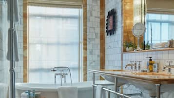 A modern bathroom with a bathtub, a large mirror, and a vanity with a sink.