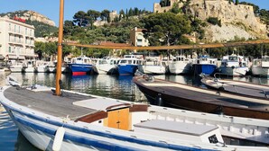 A marina with boats docked, a wooden pier, and a castle on a hill in the background. - SILVESTRI HOUSE - La Bicoque - pool / sea view / parking (Cassis)