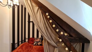 Un dormitorio con una cama, una araña y luces decorativas.