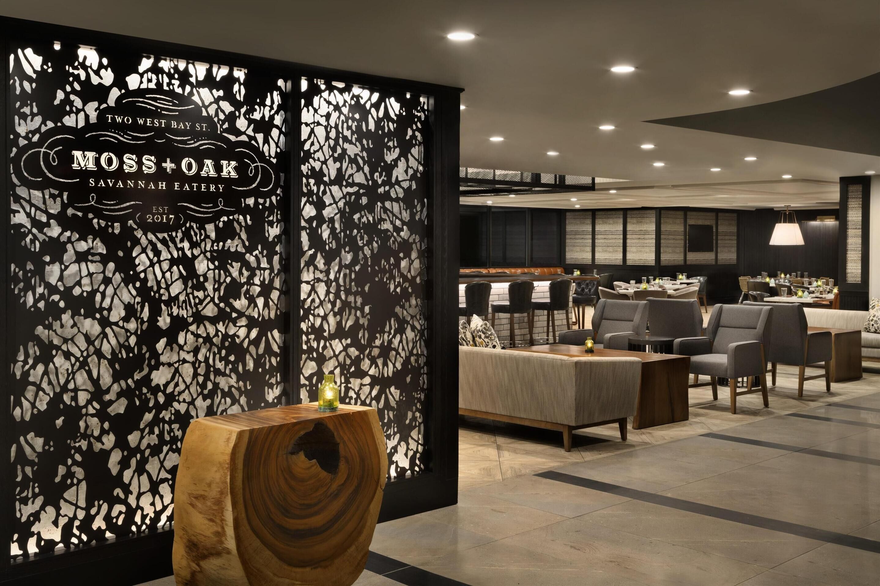 Een modern interieur met een receptiebalie, zithoek en een bar.