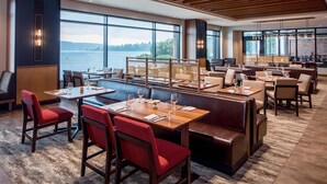 A restaurant with large windows, wooden ceiling, and multiple seating areas including booths and tables. - 2 Connecting Suites at a 4⭐️ Hotel (Renton)