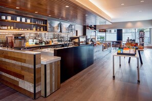 Ein modernes Café-Interieur mit Holztresen, Espressomaschinen und einer Auswahl an Kaffeebohnen.