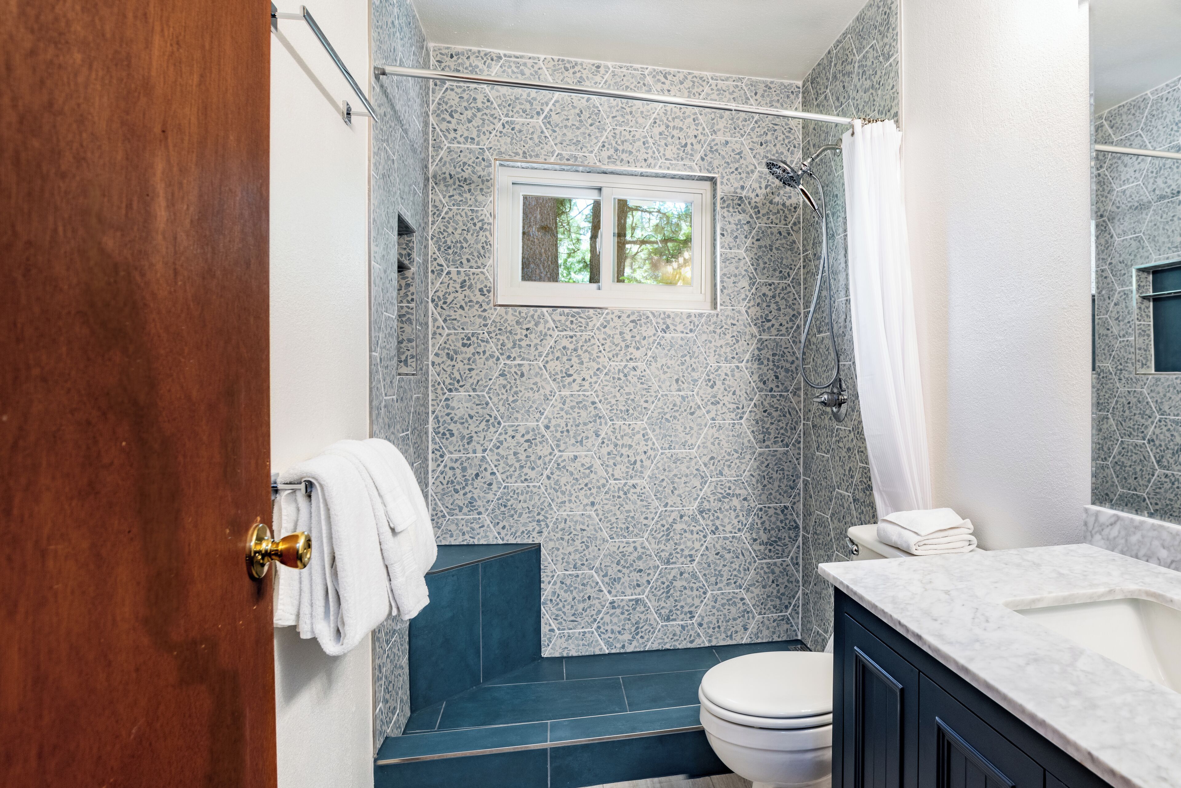 A bathroom with a shower, toilet, and sink.