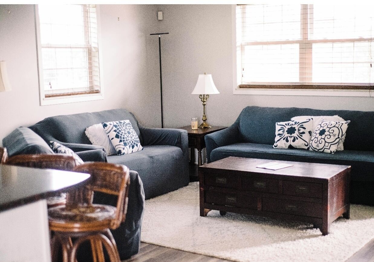 A living room with two sofas, a coffee table, a lamp, and a floor lamp.