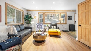 A modern living room with a sofa, armchair, ottoman, and a coffee table. - Hot Tub + Deck Dining • Mins to State Park Trails + Homewood Ski | Sweet Pine (Tahoma)