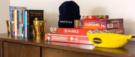 Een verzameling gezelschapsspellen en boeken op een houten oppervlak.
