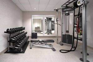 A gym with weight racks, a bench, and various exercise machines. - 2 Connecting Suites at a  Hotel (Lincoln)