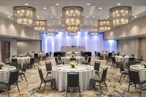 A conference room with round tables, chairs, and a stage with curtains. - 2 Connecting Suites at a 4⭐️ Hotel (Seattle)