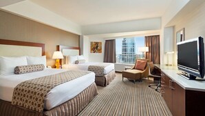 A hotel room with two beds, a TV, a desk, and a view of a cityscape. - 2 Connecting Suites at a 4⭐️ Hotel (Seattle)