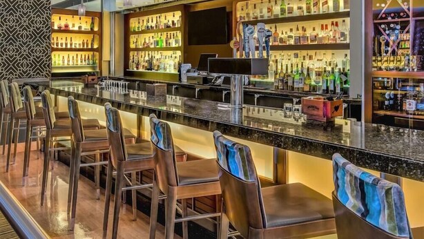 A bar area with multiple seating options and a well-stocked liquor display. - 2 Connecting Suites at a 4⭐️ Hotel (Seattle)