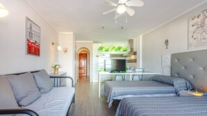 A compact hotel room with a bed, two bedside tables, a desk, a chair, and a kitchenette. - Spectacular apartment with sunset ocean views in Fanabe Beach with free WIFI (Costa Adeje)