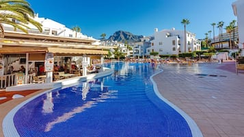 Una piscina al aire libre, una piscina climatizada