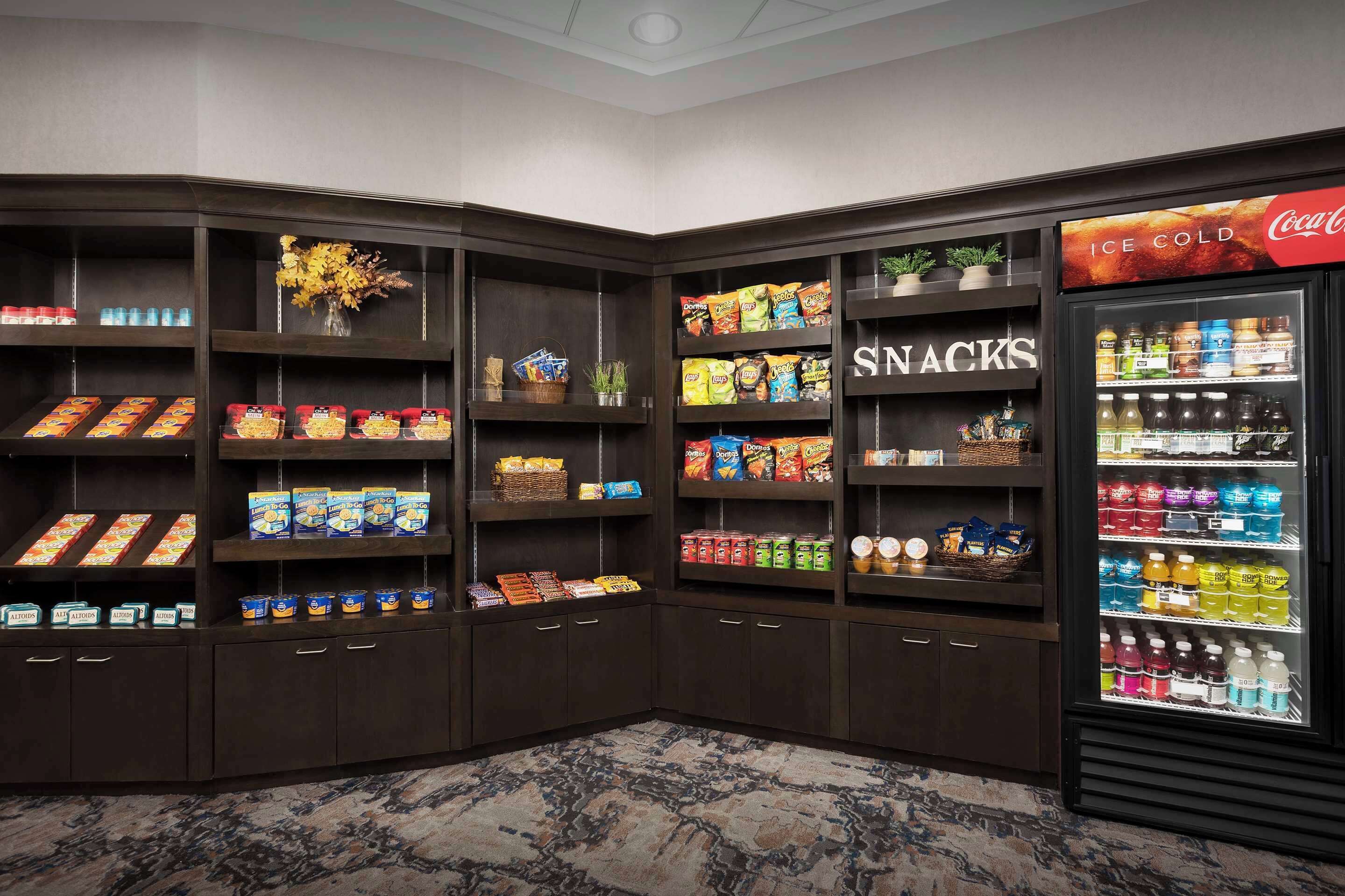 A corner vending area with snacks and beverages, including a Coca-Cola fridge.
