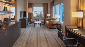 A hotel room with a sofa, chairs, a desk, a TV, and a view of the city. - 2 Connecting Suites at a 4⭐️ Hotel (Seattle)