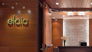 A reception area with a wooden wall, a reception desk, and a wall-mounted light fixture. - 2 Connecting Suites at a 4⭐️ Hotel (Seattle)