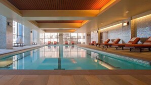 A swimming pool with lounge chairs, large windows, and a tiled wall. - 2 Connecting Suites at a 4⭐️ Hotel (Seattle)