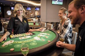 A casino gaming area with a blackjack table, a dealer, and players.