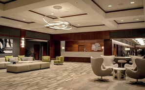 A spacious lobby with a reception desk, seating area, and a modern chandelier. - 2 Connecting Suites at a  Hotel (Fargo)