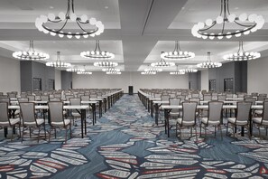 A conference room with rows of tables and chairs, large chandeliers, and a patterned carpet. - Two King Room at a  Hotel (Birmingham)