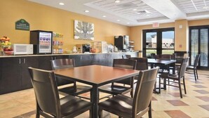 A restaurant with a counter, seating area, and a view of the outside.