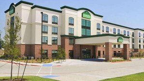 A multi-story hotel with a modern design, featuring a green roof and a prominent 'Wingate' sign.