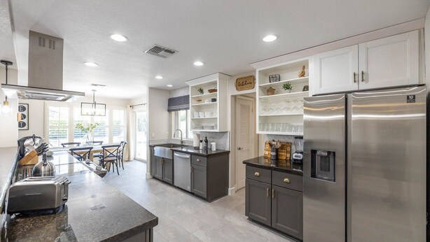A modern kitchen with stainless steel appliances, a dining area with a table and chairs, and a view of the outdoors. - Scottsdale Kierland Oasis: Heated Pool, Golf & More (Scottsdale)