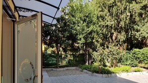 A paved courtyard with a tiled floor, surrounded by lush greenery and trees. - La Bella Modena Centro (Modena)